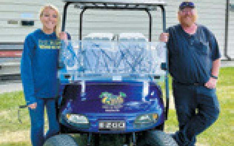 Amber Watts, who kept folks hydrated at the event, poses next to Nathan Brown. Nathan’s wife, Amber Brown, golfed in the tournament. Photo by Lauri Logsdon.