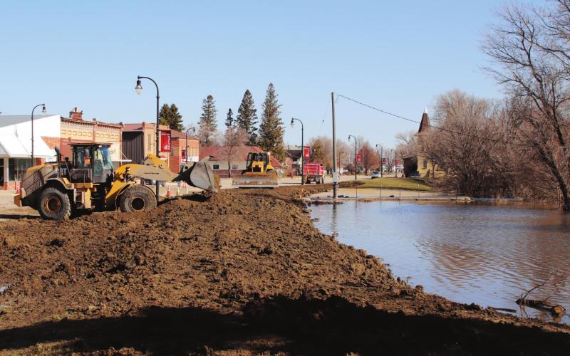Tuesday morning crews from Helms and Blawats were busy rasing the temporary dikes another foot. Pictured is the parking lot across from KodaBank looking to the north. VNV phot by Lyle Van Camp