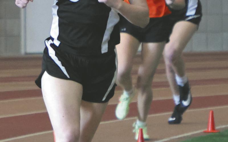 Greta Burrell and Alyssa Hoyles sandwich another runner in the Girls 300.