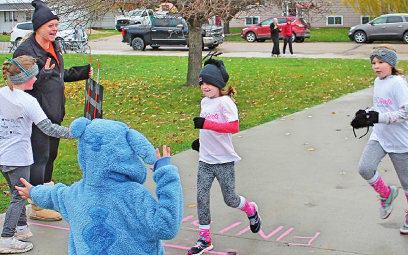 At the finish line to cheer on Natalie Helm and Lana Kalka as they finished their 5K run were Katie Dahl, Brynlee Christenson, and in costume Caleb Rarick. Photo submitted by Jamie Rarick