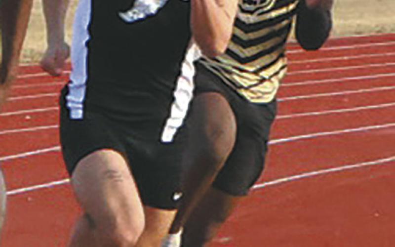 Fighting through the wind and cold, sprinters, including DVE junior Trenten Keena, rounded the track during the Mens 200m dash. Keena earned a 7th-place finish in the competitive event. Photo by Jamie Rarick