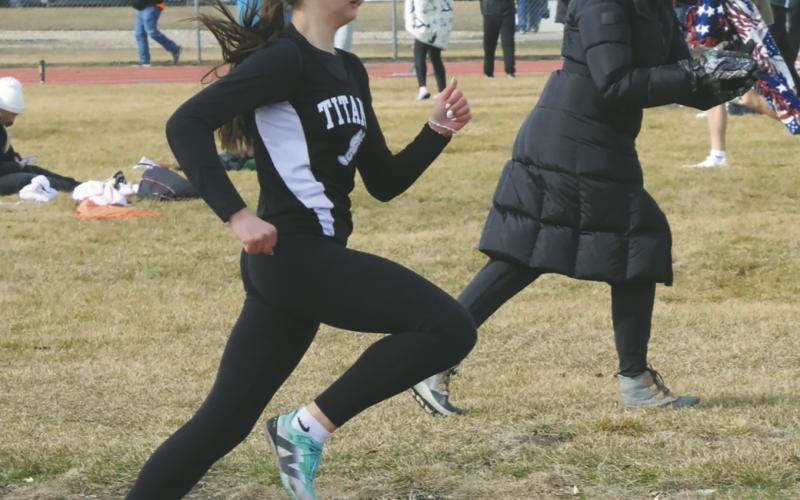 Serving as both a coach and a mom, Coach Jodi Fedje moves along the sidelines, encouraging Rosalyn Fedje during the girls 400m. Fedje won second place in the race. Photo by Jamie Rarick