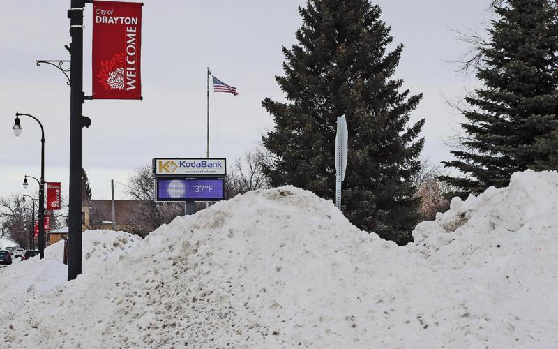 The electronic sign seen in the background beyond the snowpiles created from the street plowing showed a temperature of 37 degrees on Tuesday afternoon. VNV Picture by Lesa Van Camp
