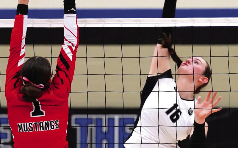 Ingrid Myrdal slams the ball over the net towards Mustangs' senior Sadie Armbrust. Photo by Larry Stokke