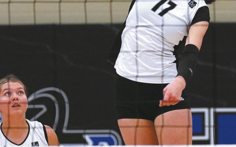 Brooke Gullickson watches as Elizabeth Fedje hits the ball over the net. Photo by Larry Stokke