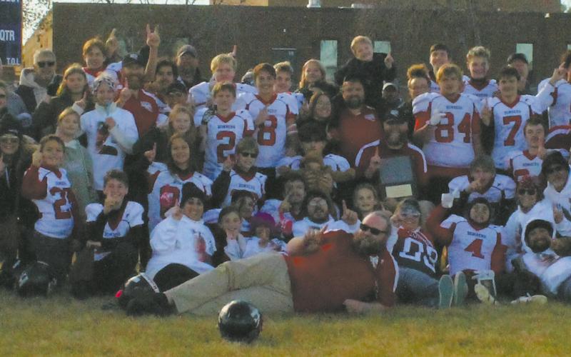 A supportive crowd of family and friends traveled to Trenton, N.D., for Saturday's 6-Man Football State Championship game and posed for a photo following the Bombers' victory. Photo by Candie Weyrauch.