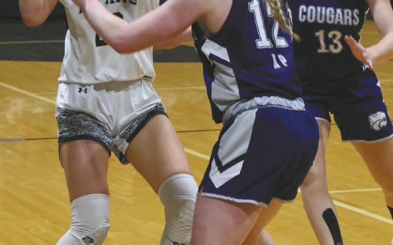 DVE senior Jaelyn Johnson looks to move the ball past North Prairie Defenders Payton DeMers and Ella Pederson. Photo by Jamie Rarick