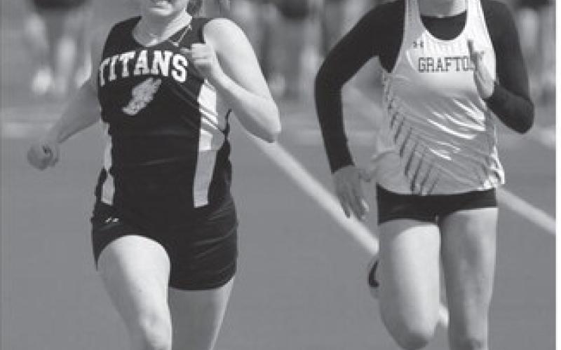 Greta Burrell, left, took first in her heat in the 100 meter dash. At right is Grafton Junior Molly Bjorneby.
