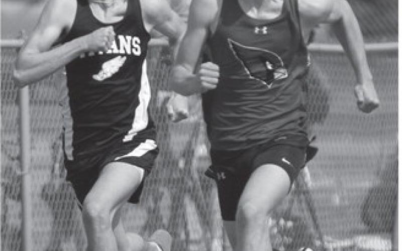 Brady Reilly, left duels with a Carrington runner while competing in the 100 meter dash in Grafton Friday.