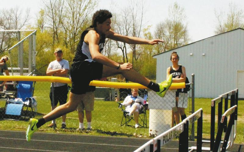 (Left) Soaring over the hurdles, junior Elizabeth Fedje took the lead to a first-place finish in the womens 300m hurdles. (Above) On his approach, sophomore Mason Pollestad extends to clear in the mens 110m hurdles. Pollestad placed 2nd with a personal record of 16.52. Photos by Jamie Rarick