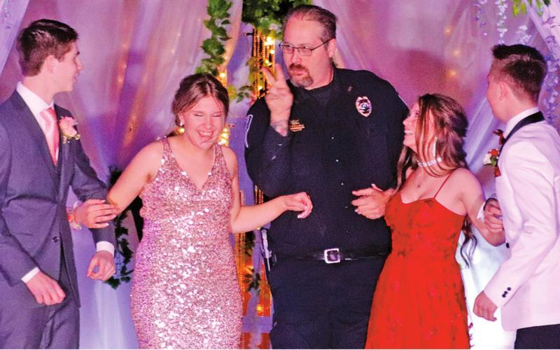 Drayton City Officer Ian Mattice let the boys know that he had his eyes on them and then escorted their dates through the walkway of the Grand March Pictured l to r: Evan Feltman, Rylee Maurstad, Officer Mattice, Jazalyn Rathke, and Hunter Johnson. VNV Photo by Lesa Van Camp