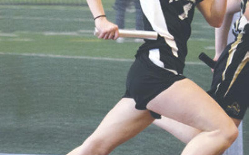 Easton Larson running a leg of the girls’ 4 x 300 relay. Photo by Lyle Van Camp.