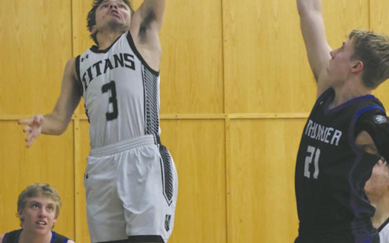 DVE’s Trenten Keena puts up the shot as Hatton-Northwood forward Drew Iverson. Photo by Jamie Rarick