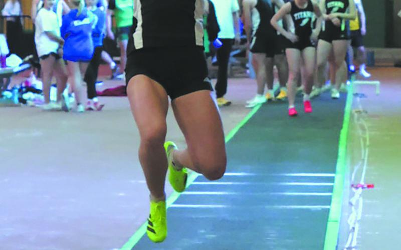 Launching off the runway, DVE senior Elizabeth Fedje flies through the air in the Women's Long Jump competition. Fedje finished second in the event with a distance of 15' 7'. Photo by Jamie Rarick