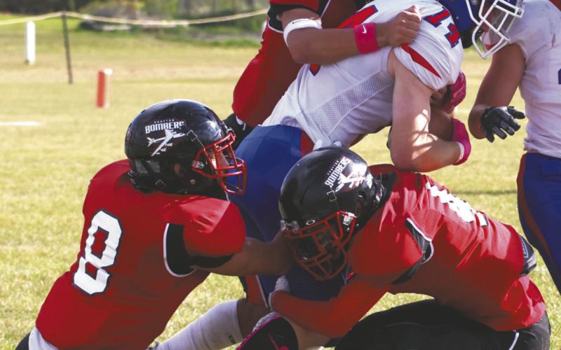 Three Bombers defenders stop the ball carrier in a group effort. Photo by Lyle Van Camp
