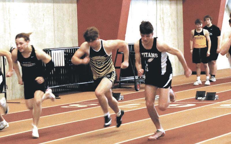 Pushing off the blocks, three Titan sprinters, Carter Johnson, Brady Reilly, and Carter Oberg, race to the finish line during the boys 60 meter dash. Photo by Jamie Rarick