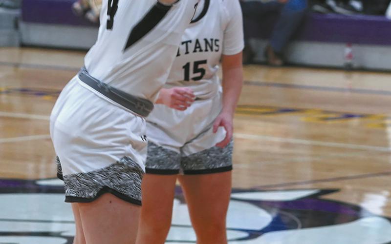 Gretta Burrell sinks a long three point shot against the NP Cougars. Photo by Larry Stokke