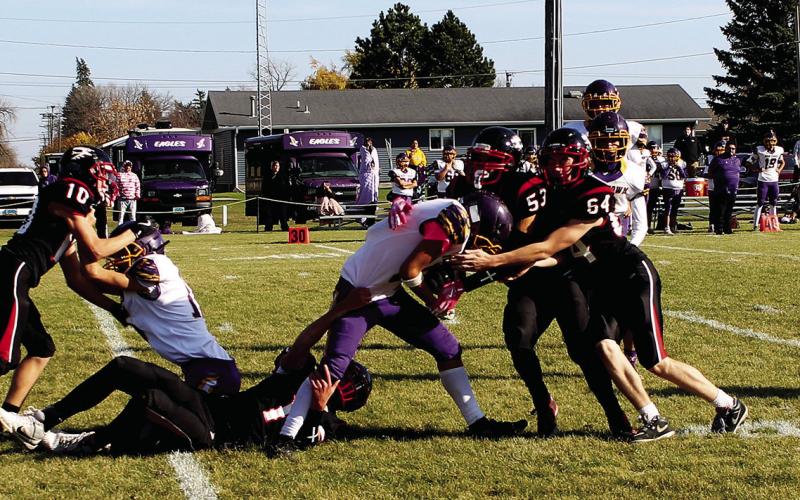 Chey Sehrt, Jerimiah Johnson, and Landon Mapel work together to bring down the Eagle ball carrier. Photo by Jamie Rarick.