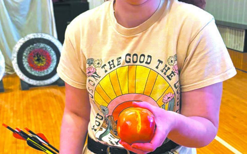 Ruby H. holds up the apple she shot off the target. Submitted photo.