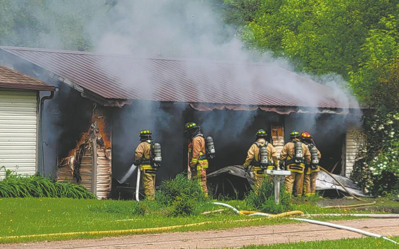 Members of the Grafton Volunteer Fire Department assess the damage and look for hot spots in the garage at 116 Wakeman Avenue in Grafton Monday afternoon. Photo by Mike Steinfeldt.