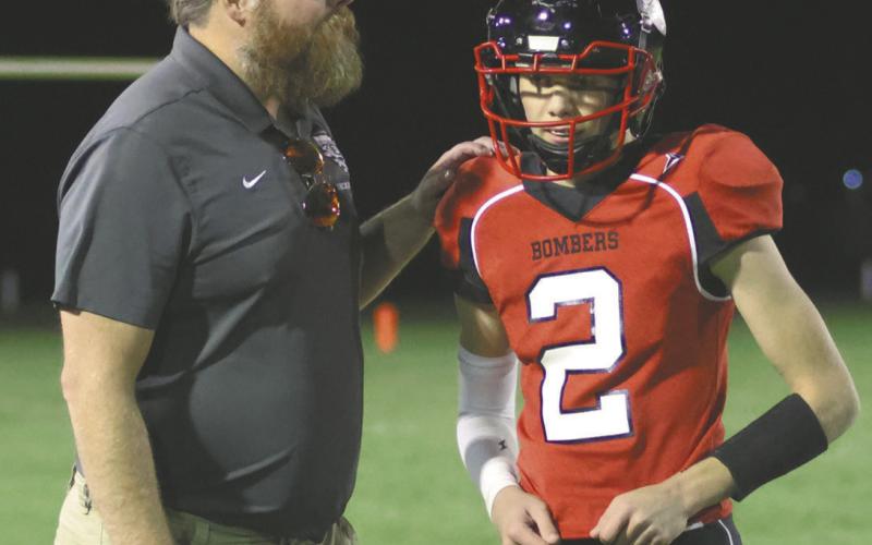 Coach Foster tells quarterback Quinn Passa what play he wants next. Photo by Lyle Van Camp