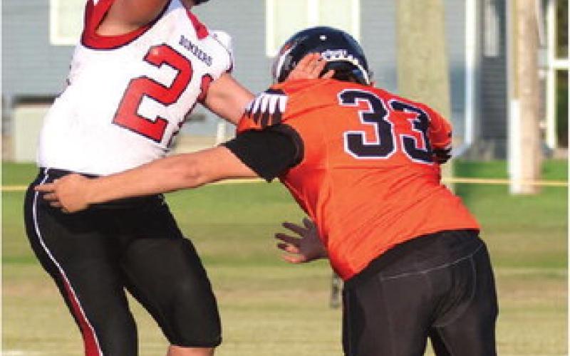 Hunter Johnson gets a pass off before being hit by the Warrior’s TJ Longie. Photo by Lyle Van Camp.