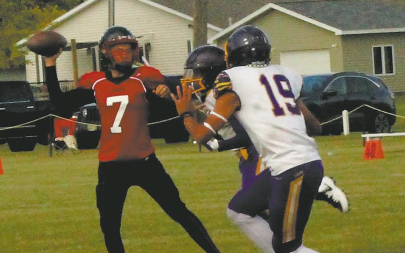 Under pressure, Max Foss-Pokrzywinski looks to pass over Eagle defenders. Photo by Jamie Rarick