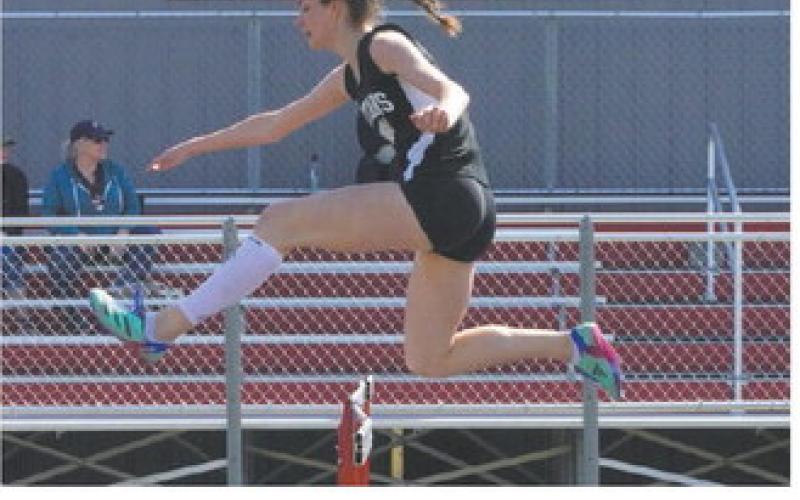 Elizabeth Fedje speeding over a hurdle at the Langdon Invitational. Photo by Larry Stokke.