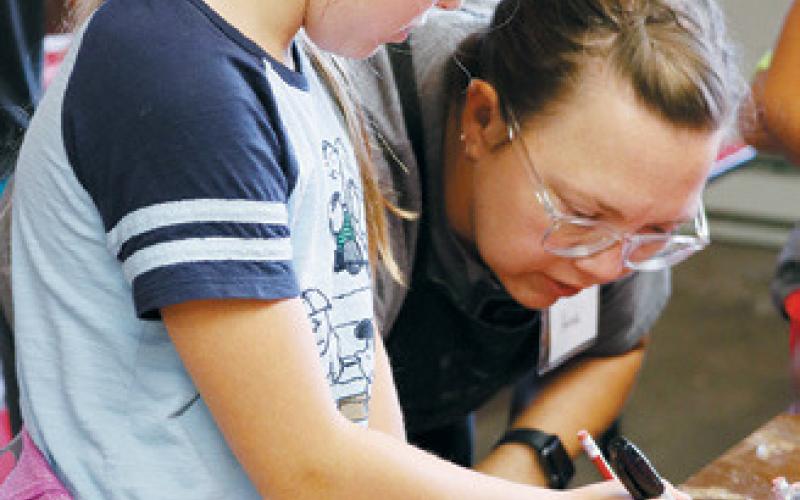 Art instructor, Anna Jacobsen demonstrates how to carve a linoleum printing plate.