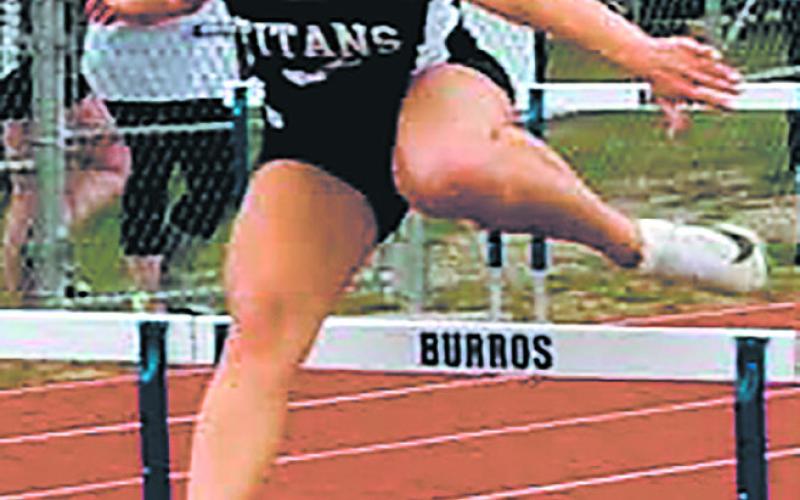 Reese Fering clears the hurdles, placing 4th in the girls 100 hurdle competition. Photo by Jamie Rarick