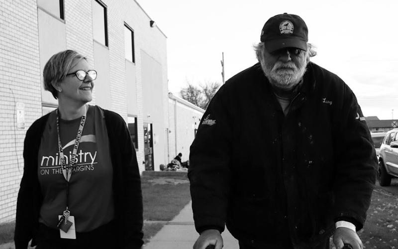 Michael Hauck, a homeless veteran, walks next to his behavioral health manager before being transported to a nearby hotel as he awaits approval to move into a nearby apartment. (Photo by Michael Achterling/North Dakota Monitor)