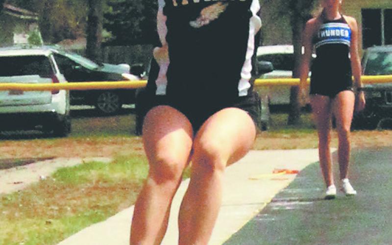 DVE freshman Violet Hoyles launches forward in womens long jump, finishing third with a personal record of 13' 8.5' in Larimore on May 10. Photo by Jamie Rarick.