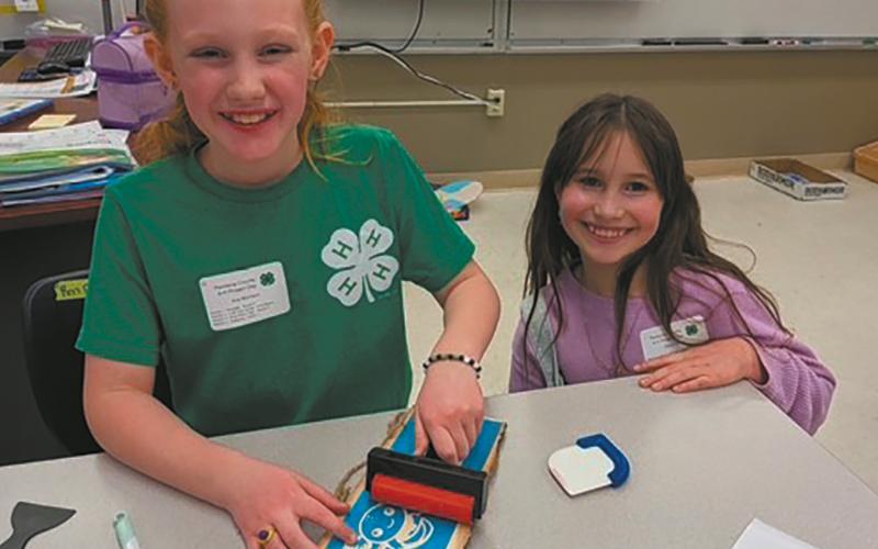 Ava and Olive personalize their signs in the sign etching class. Submitted photo
