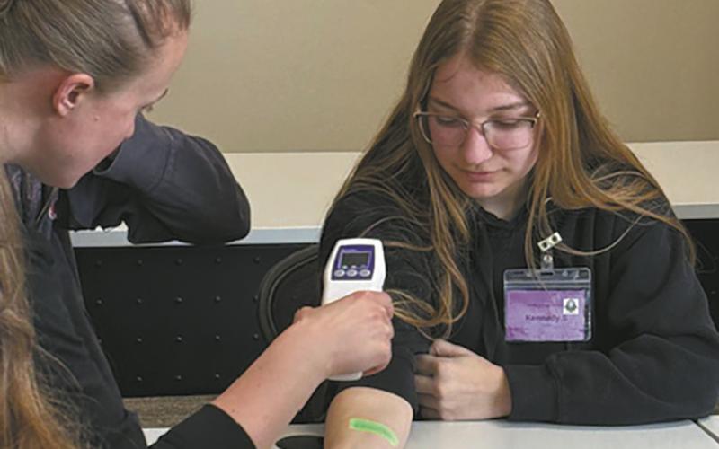 A vein finder is demonstrated on Kennedy Osowski during Scrubs Camp. Submitted photo.