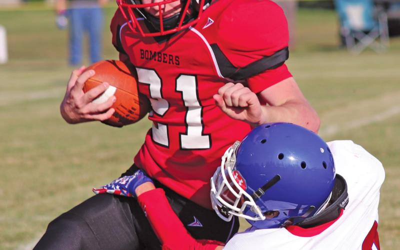 Cayden Quibell attempts to gain some yards before being taken down by Wildcat Jack Sailer in Saturday afternoons match up on the Drayton grid iron. VNV Photo by Lesa Van Camp