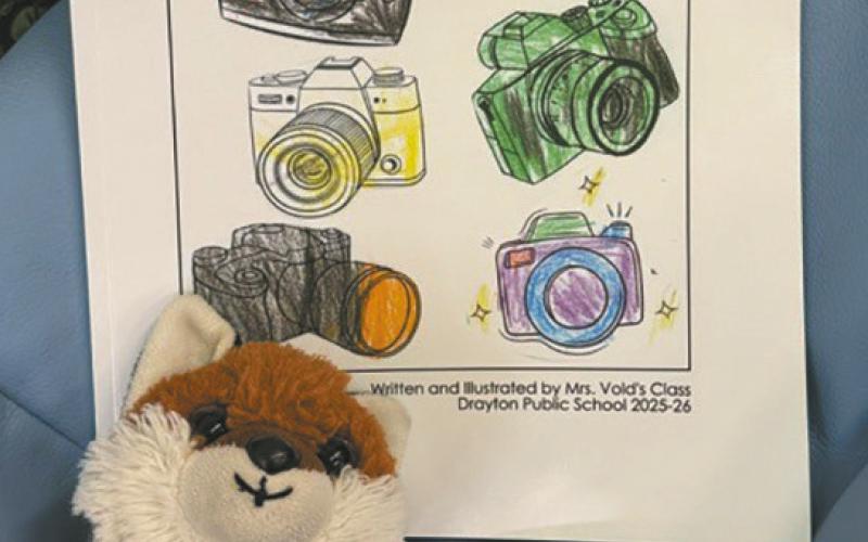 The cover of the book was colored by Mrs. Vold’s class in preparation for publication. The finished book sits with a favorite stuffed animal. Submitted photo