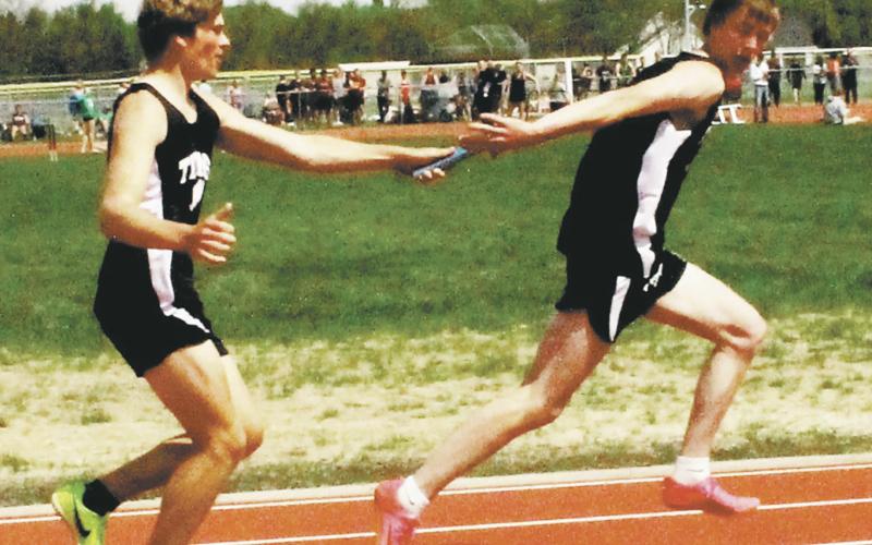 Sam Kittelson hands off to Jack Langerud in the boys 4x100 relay. The relay team, also including Mason Pollestad and Carter Johnson, finished third, qualifying for state. Photo by Jamie Rarick