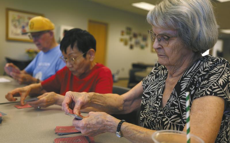 From left, Earl Nelson, Masayo Sollid and Marlys Young, all of Fargo, play a card game with fellow senior citizens on Wednesday, July 2, 2025, at the Ed Clapp Park Senior Center in south Fargo. Anna Paige / The Forum