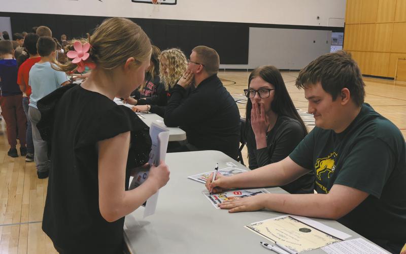 Grant Uggerud signs an autograph for an excited younger student. Photo by Rebecca Davis