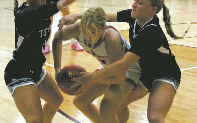 DVE's Jacey Nelson and Reese Fering fight for the ball against a Midway-Minto ball carrier. Photo by Jamie Rarick