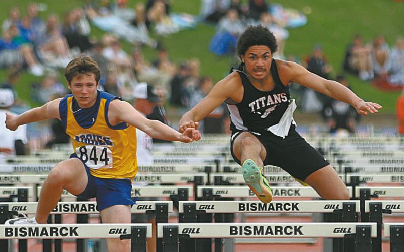 D-V-E’s Mason Pollestad, right, runs side by side with Velva’s Brady Hoff during a preliminary heat in the Boys’ Class B110 Meter Hurdles at the State Track Meet in Bismarck on Friday. Photo by Mike Alan Steinfeldt