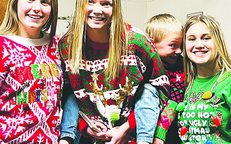 Kiara Aasand, Easton Larson, Elliot and Claire Thompson pose in their ugly sweaters. Photo from Lauri Logsdon.