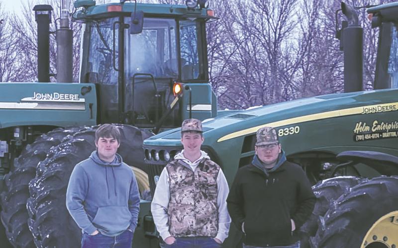 Ryan Corrik, Jaxon Wilson and Carlos Quezada stand with their tractors on Tractor Day. Submitted photo