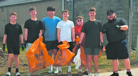 Mr. Riddle gives a thumbs up as his group shows off their bounty of collected trash. Photo by Christine Jensen