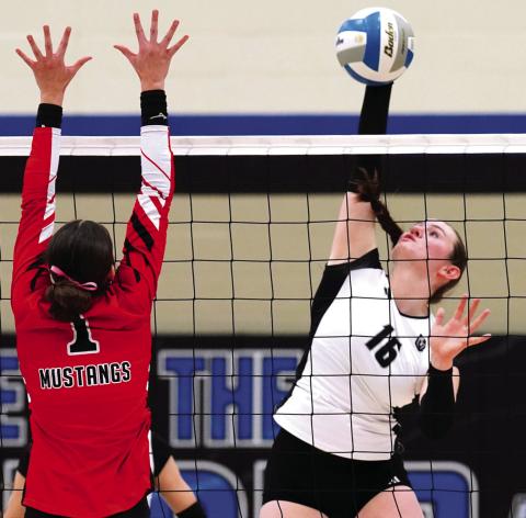 Ingrid Myrdal slams the ball over the net towards Mustangs' senior Sadie Armbrust. Photo by Larry Stokke