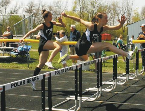 DVE teammates Jocelyn Vold and Elizabeth Fedje leap over the hurdles to a 2nd and 3rd place finish respectively, both moving on to the state competition in the womens 100m hurdles. Photo by Jamie Rarick