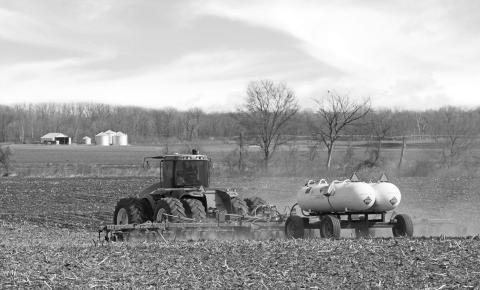 A tractor pulls anhydrous ammonia tanks to fertilize a farm field. (iStock Getty Images Plus)