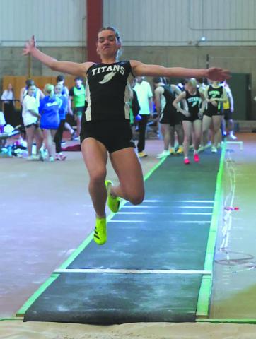 Launching off the runway, DVE senior Elizabeth Fedje flies through the air in the Women's Long Jump competition. Fedje finished second in the event with a distance of 15' 7'. Photo by Jamie Rarick