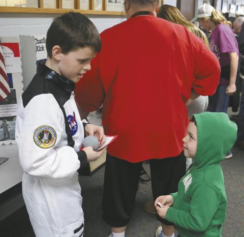 Calvin Helm is entertained by his big brother Henry Helm's presentation about the first astronaut on the moon, Neil Armstrong. Photo by Jamie Rarick