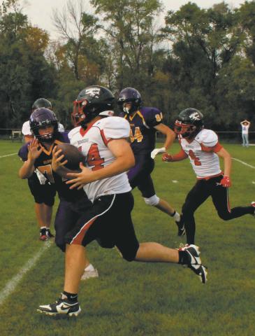 Fighting off the Clipper defense, Praise Chairez carries the ball for a Bomber touchdown. Photo by Jamie Rarick